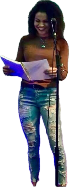 Cyndiii Deusa at a microphone stand, reading aloud from her poetry, smiling.